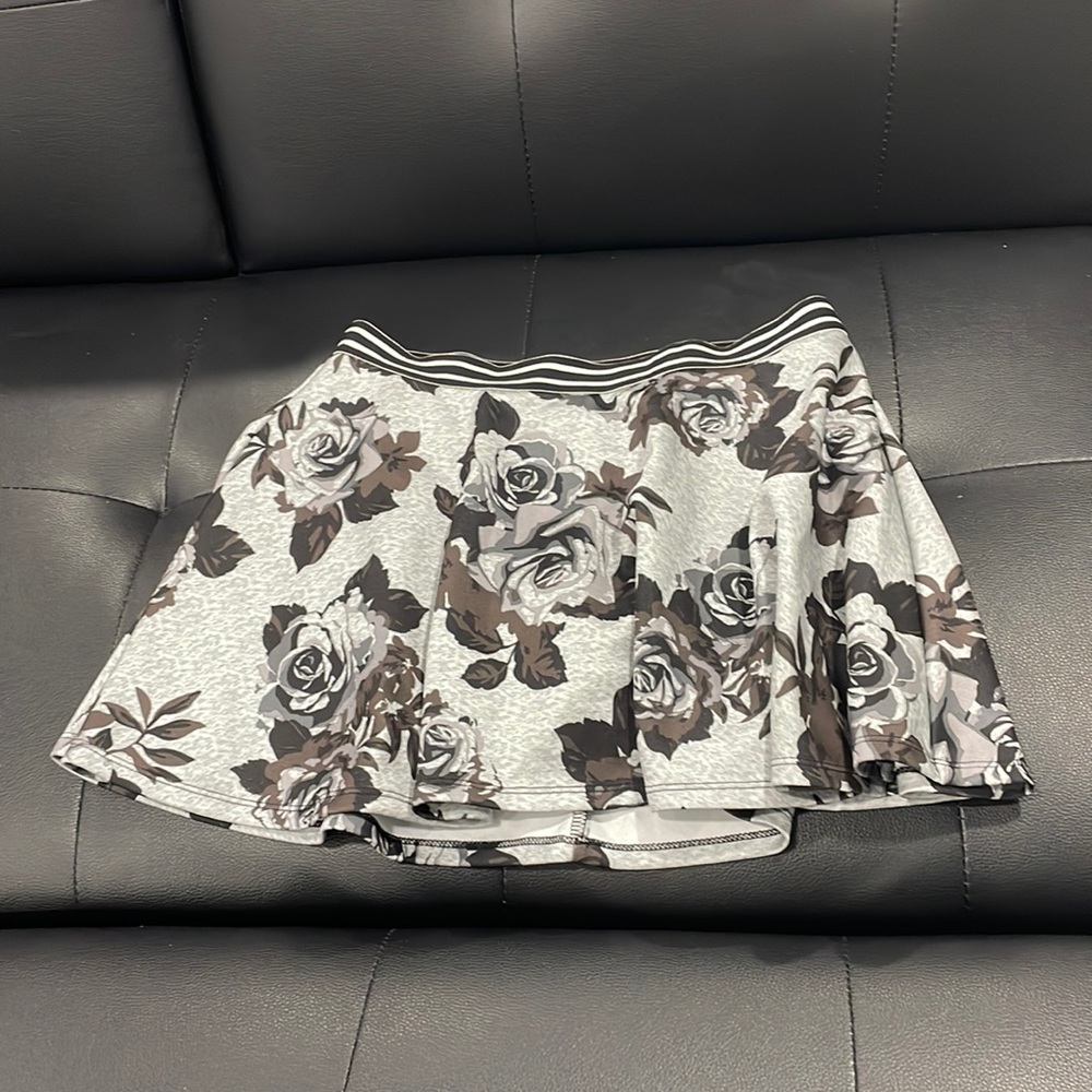 Floral silver skirt; undershorts present; brand: Justice; size 14